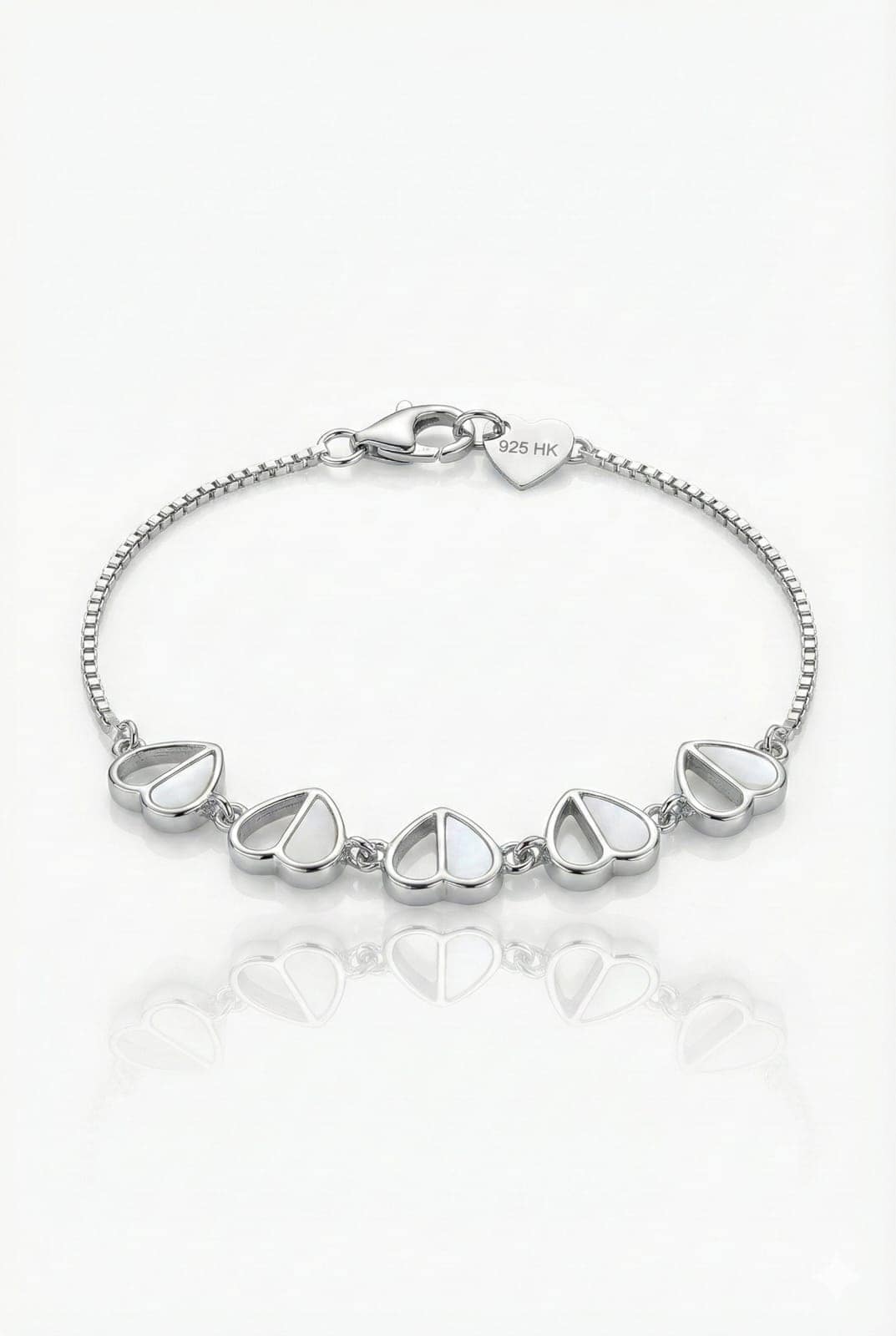 925-silver-mother-of-pearl-heart-charm-bracelet-box-chain A delicate 925 Sterling Silver bracelet for women featuring five heart-shaped charms with white mother of pearl inlays, connected by a fine silver box chain with a lobster clasp and a 925 HK heart tag